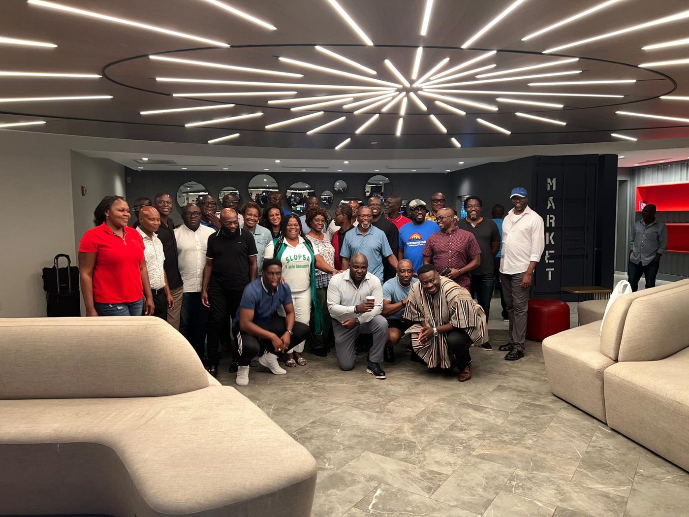 A large group of Akatakyie members and guests posed together in a hotel lounge
